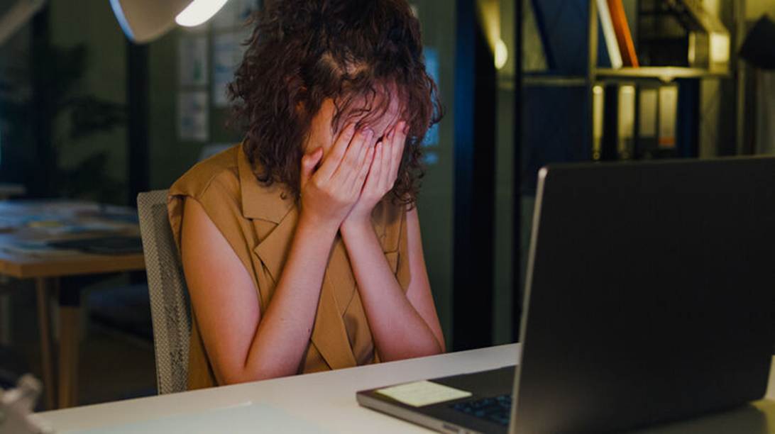 Woman crying in front of computer screen - Sexual Harassement